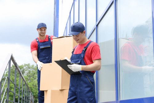 Piano removals team carefully moving an upright piano in Queens Park