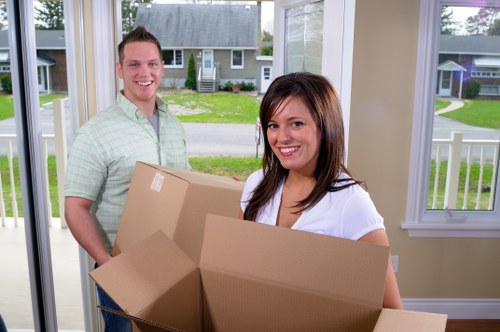 Local removals team transporting boxes and furniture from a flat