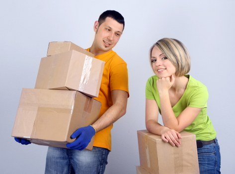 Professional packer wrapping fragile household items during a move in Queens Park